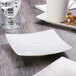 A white Schonwald square porcelain saucer on a table.