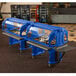 A navy blue Cambro Versa Salad Bar on wheels with two food trays in a buffet line.