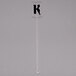 A clear plastic rectangular stirrer with the letter K on it.