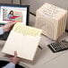 A hand opening a Smead legal size file jacket folder with papers inside.