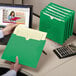 A person holding a Smead green file folder.