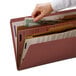 A hand putting a piece of paper into a Smead SafeSHIELD legal size file folder.