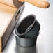 A stack of small round Matfer Bourgeat ramekin pans on a counter.