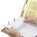 A hand holding a Smead legal size fastener folder with a proposal document.