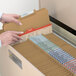 A person's hands opening a file cabinet with Smead legal size file folders.