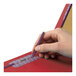 A person writing on a red Smead SafeSHIELD legal size classification folder with a pen.