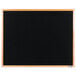 A black Aarco indoor message board with an oak wood frame.