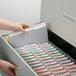 A hand taking a Smead file folder out of a file drawer.