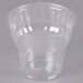 A WNA Comet clear plastic sundae cup on a gray surface.