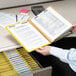 A person holding a Smead file folder with papers and a calculator.