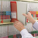 A person holding a Smead file folder with green and gray labeling
