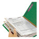 A hand holding a green Smead SafeSHIELD legal size classification folder with documents.