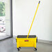 A yellow Rubbermaid mop bucket with a handle on the side.