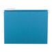 A teal Smead hanging file folder with a white repositionable poly tab.