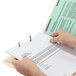 A person holding a Smead Heavy Weight Letter Size Classification Folder with papers.