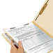 A hand holding a Smead file folder.