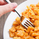 A Libbey stainless steel dessert fork holding a piece of pasta.