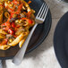 A plate of pasta with vegetables and a Libbey stainless steel dinner fork.