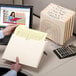 A hand holding a Smead letter size file folder with papers inside.