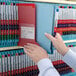 A person holding a Smead red file folder.