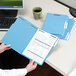 A person holding a blue Smead file folder.