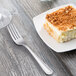 A dessert fork on a plate with dessert.