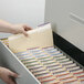 A hand opening a file cabinet to reveal Smead Manila file folders.