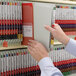 A person holding a Smead red SafeSHIELD file folder.