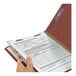 A hand holding a Smead heavy weight classification folder with a document.