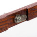 A close up of a wooden door handle with a lock on a cherry wood frame.