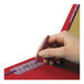 A hand using a pencil to write on a red Smead SafeSHIELD classification folder.