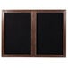 A black framed wooden cabinet with black felt message board doors.