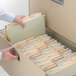 A hand opening a file drawer filled with Smead SuperTab file folders.