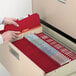 A person opening a file cabinet with Smead red classification folders.