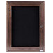 An Aarco walnut framed enclosed black felt message board with a lock.