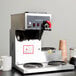 A Bloomfield automatic coffee brewer on a counter with cups on the hot plate.