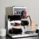 A Bloomfield Koffee King coffee maker on a counter with a glass pitcher and a mug.