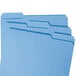Three blue Smead file folders with assorted tabs.