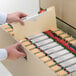 A person opening a file cabinet using a Smead legal size file jacket.