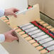 A person opening a file cabinet drawer with a Smead file.