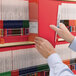 A person holding a red Smead Shelf-Master file folder.