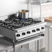 A stainless steel Garland GTOG36-6 liquid propane 6-burner countertop range with control knobs and a pot on one burner.
