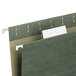 A close-up of a green file folder with a Smead white rectangular tab inserted in it.