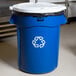 A blue Rubbermaid Brute recycling can with a white lid and a recycle symbol.