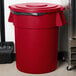 A red Carlisle Bronco trash can lid on a red trash can.