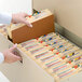 A hand opening a file drawer filled with Smead file folders.