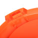 An orange Carlisle round trash can lid.