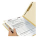 A hand holding a Smead Heavy Weight Letter Size Classification Folder with a piece of paper in it.