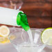 Carlisle white and green liquid being poured into a clear container.