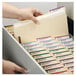 A hand putting a Smead legal size file folder into a file cabinet.